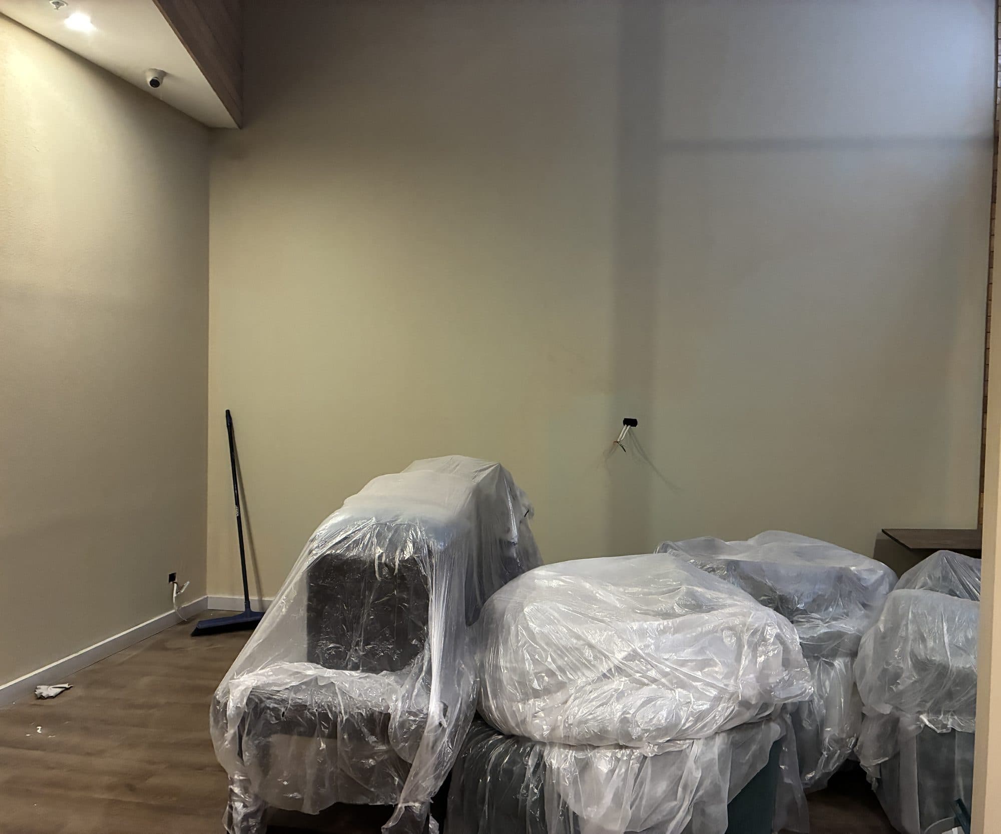An empty shop room with furniture wrapped in plastic