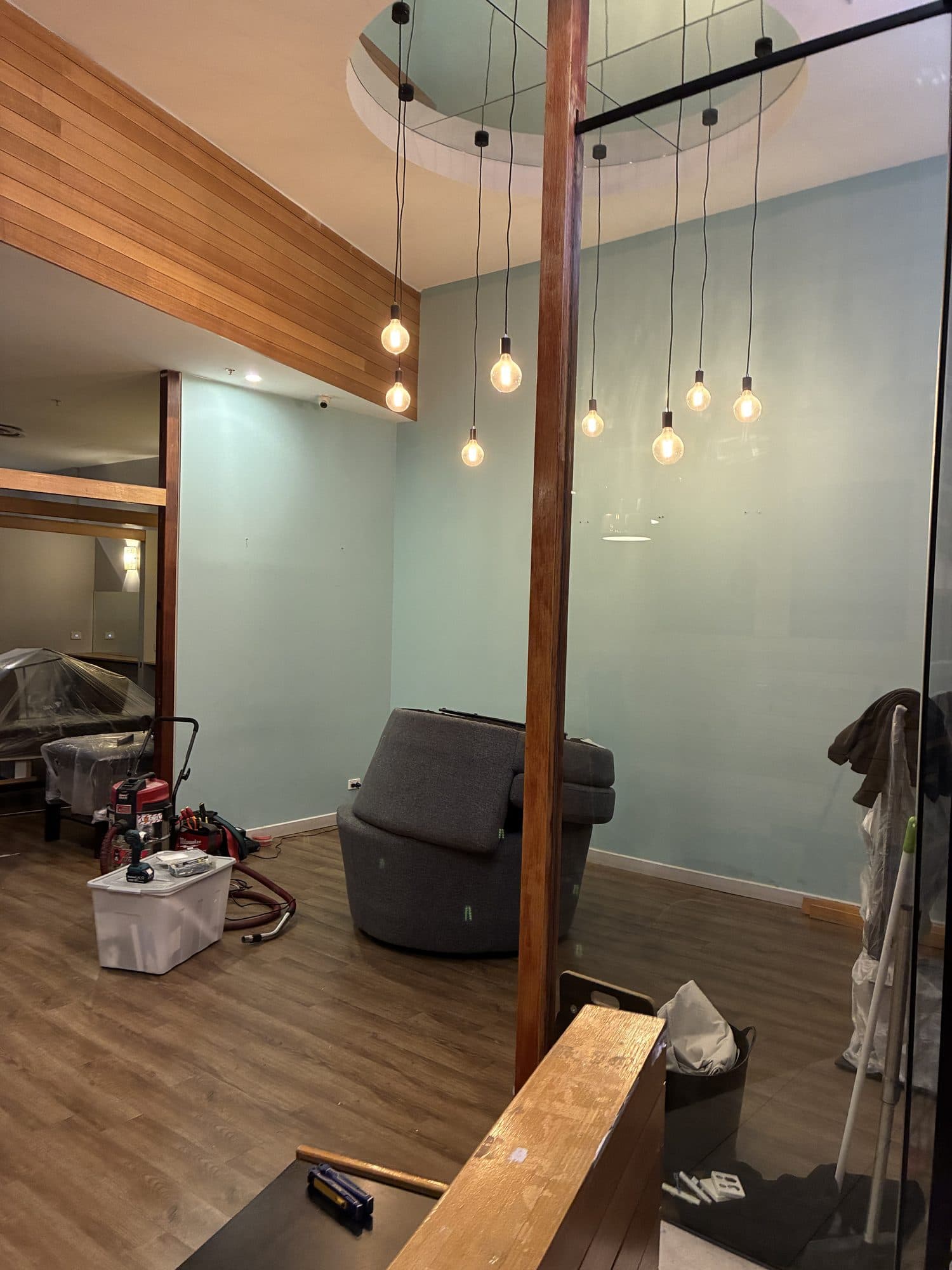 A timber post and bulkhead with pendant lights hanging behind