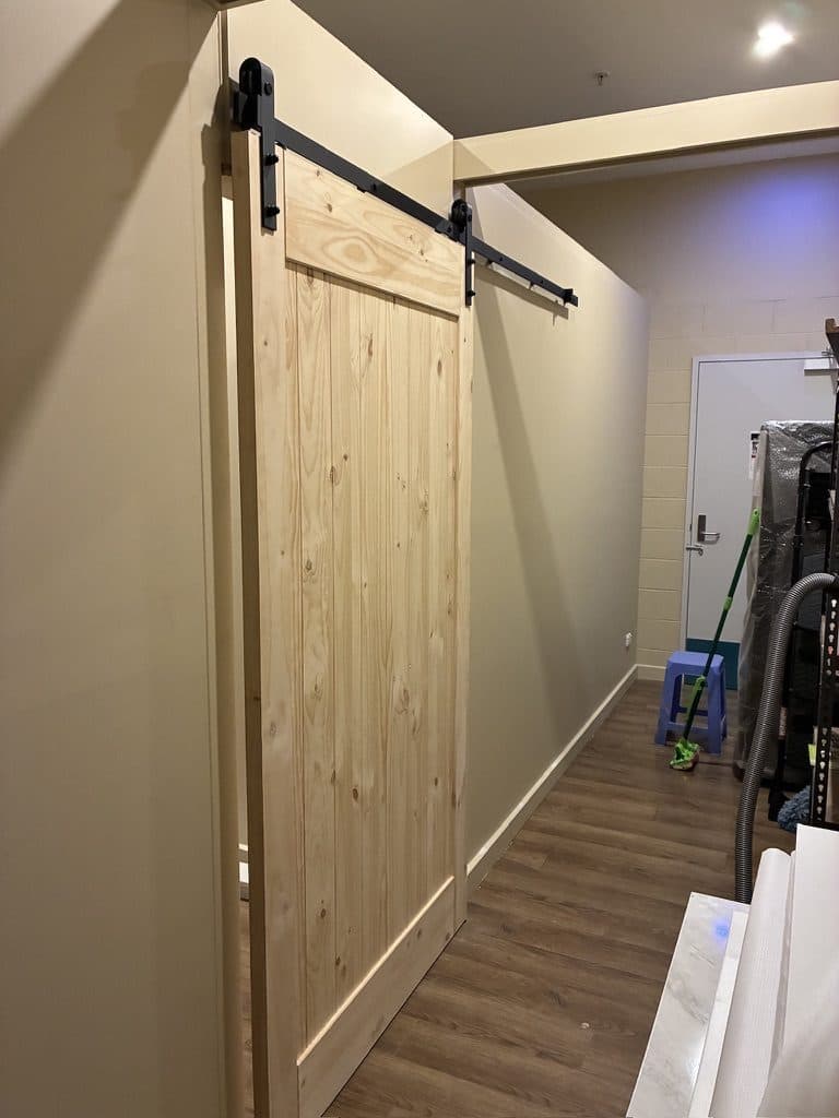 A timber barn door on a black sliding track
