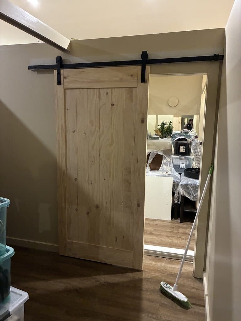 A timber barn door slid open to the next room