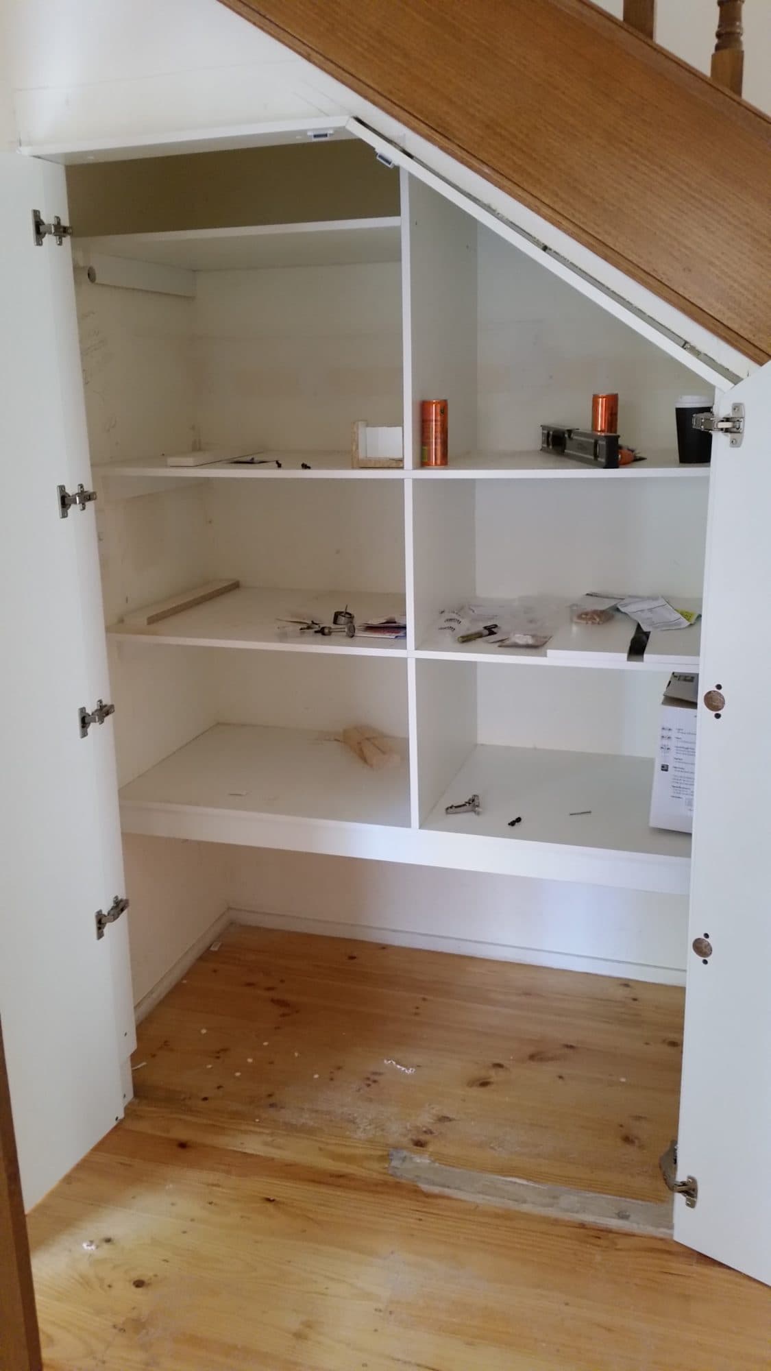 An under-stair cupboard with its doors open