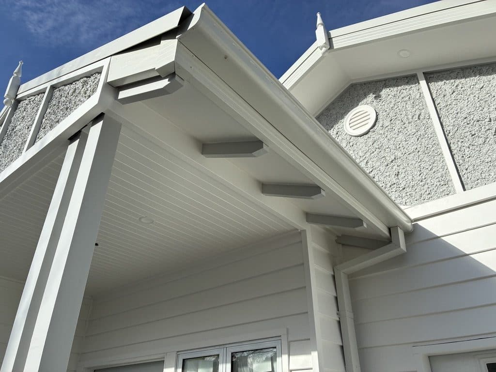 A finished eave with lined soffit and brackets on a white weatherboard gable