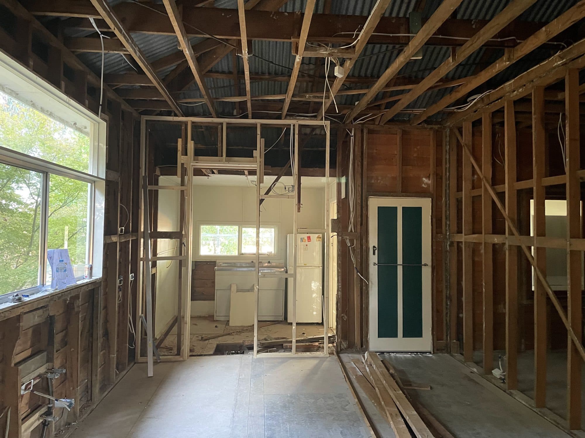 An interior stripped back to the timber frame, with new wall framing and open ceiling joists