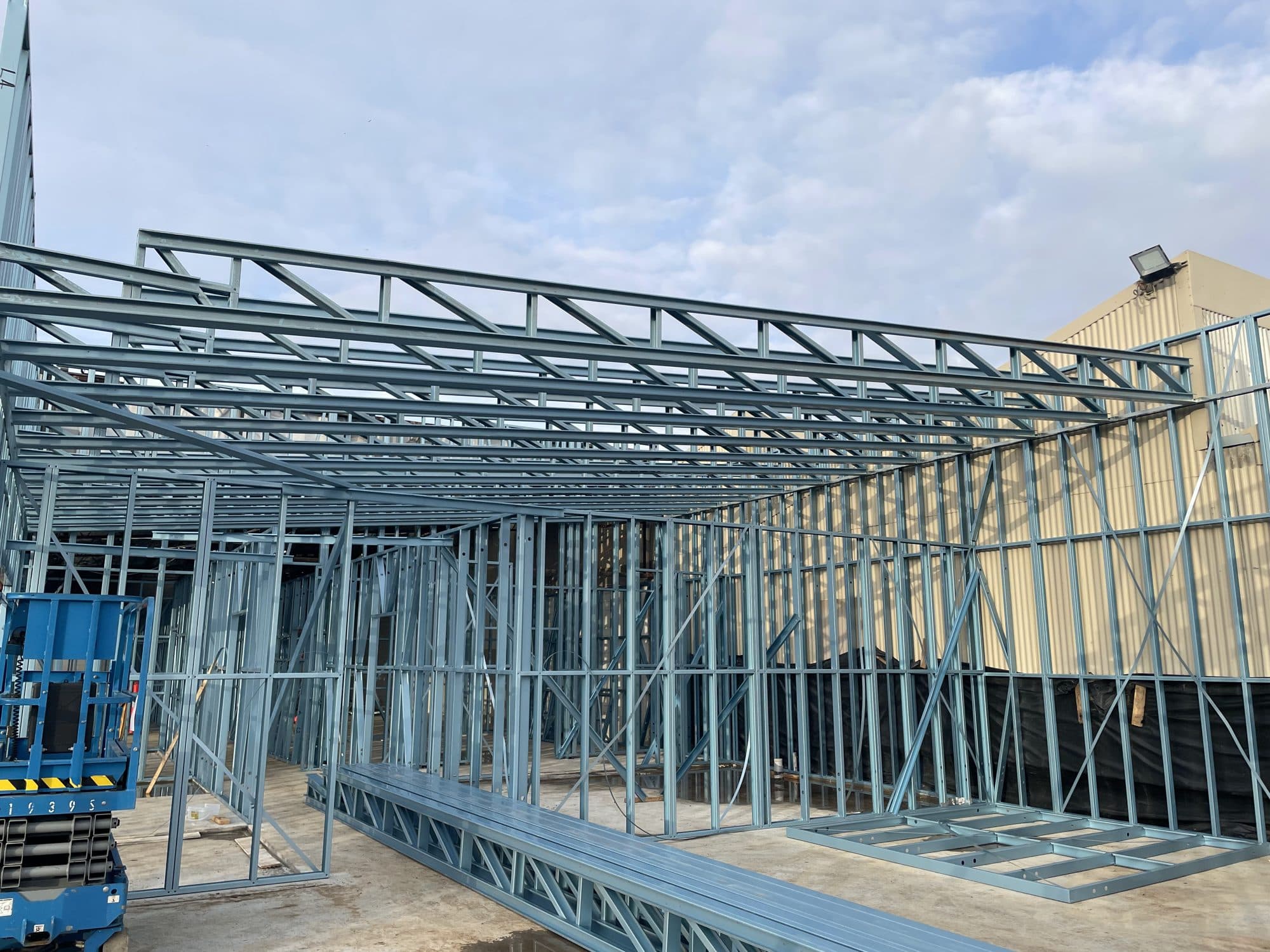 Steel roof trusses on newly framed walls, seen from outside