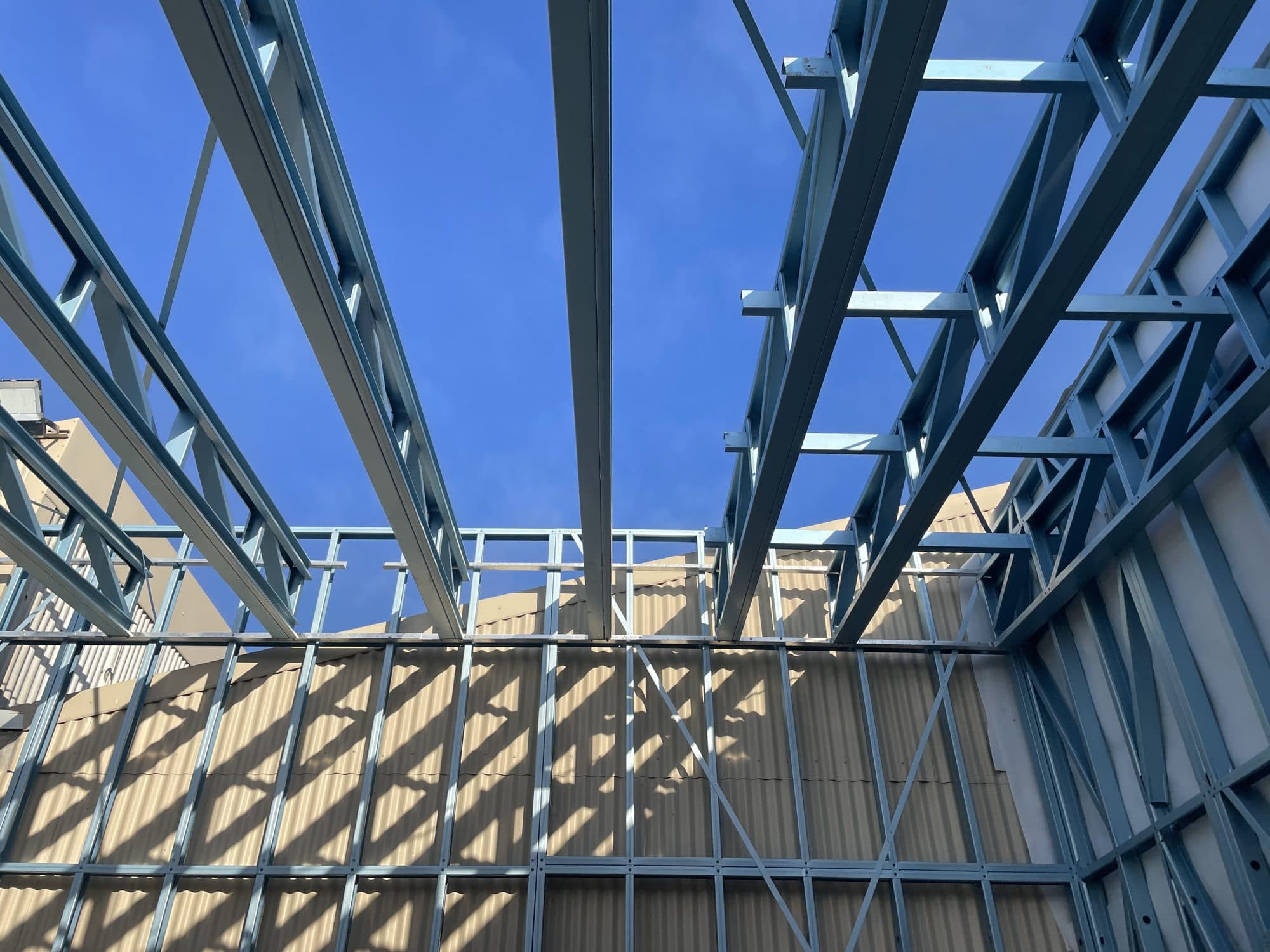 Steel roof trusses against a blue sky