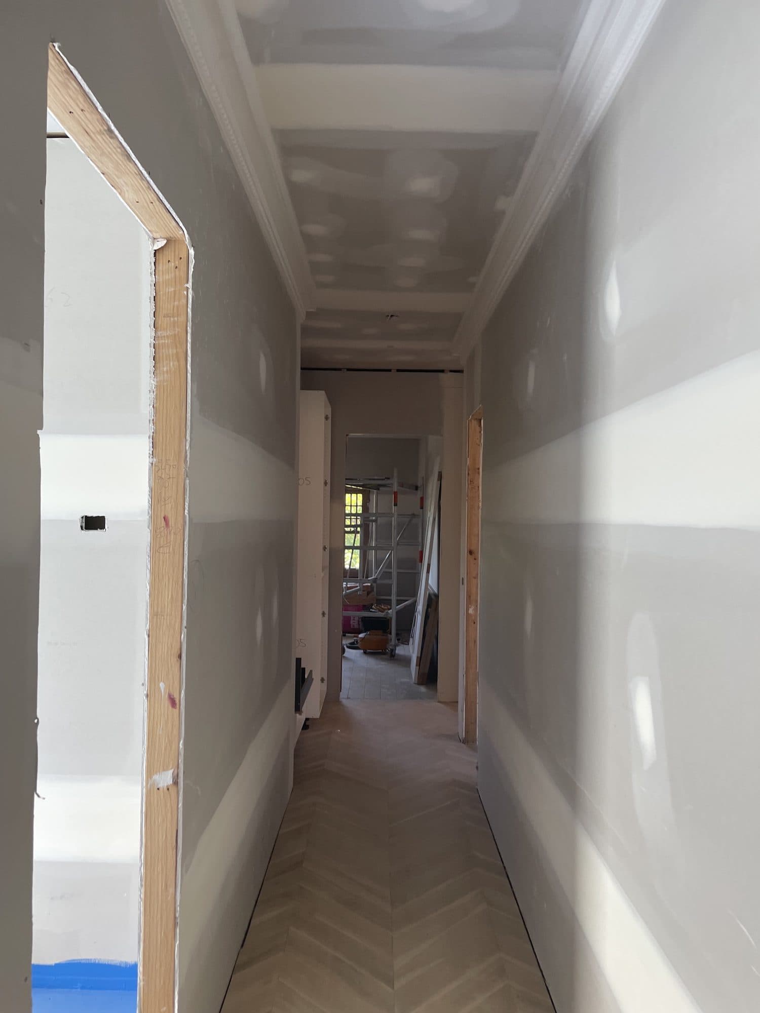 A long hallway with set plaster walls and cornice