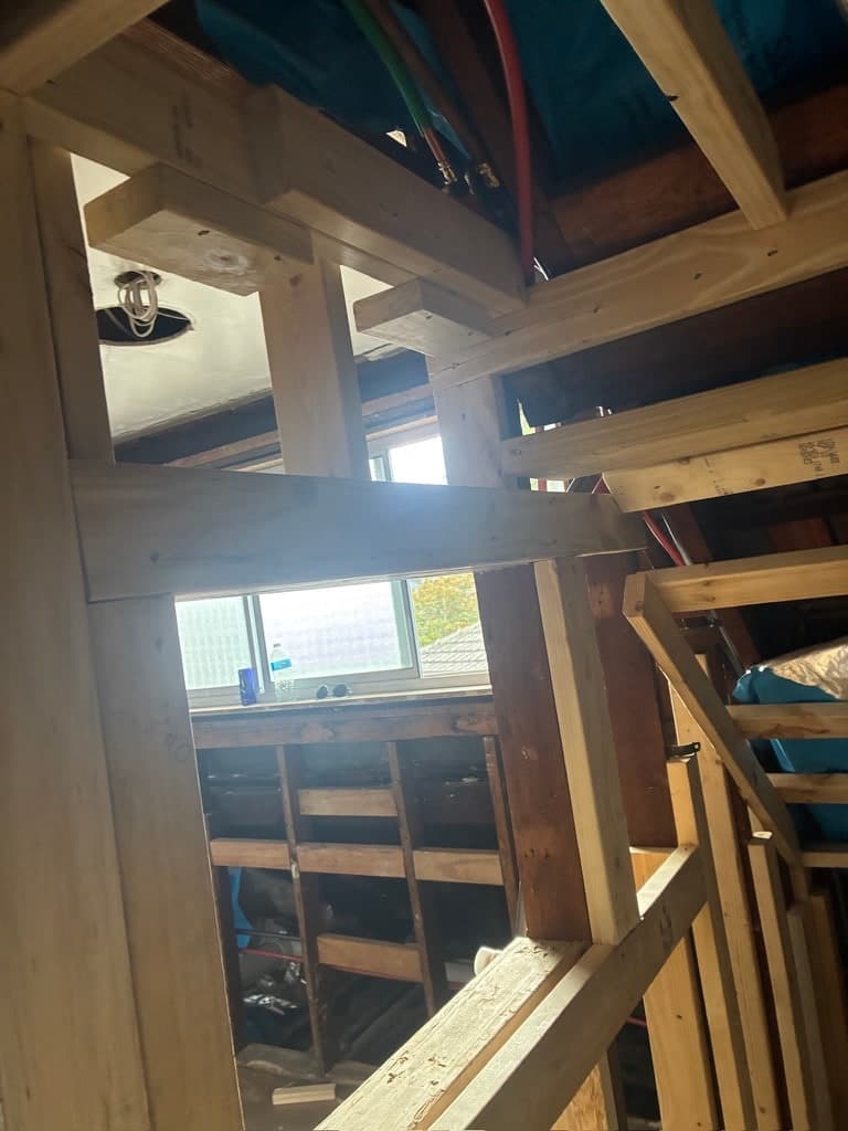 New stud walls framed into the roof space, with the rafters and sarking above