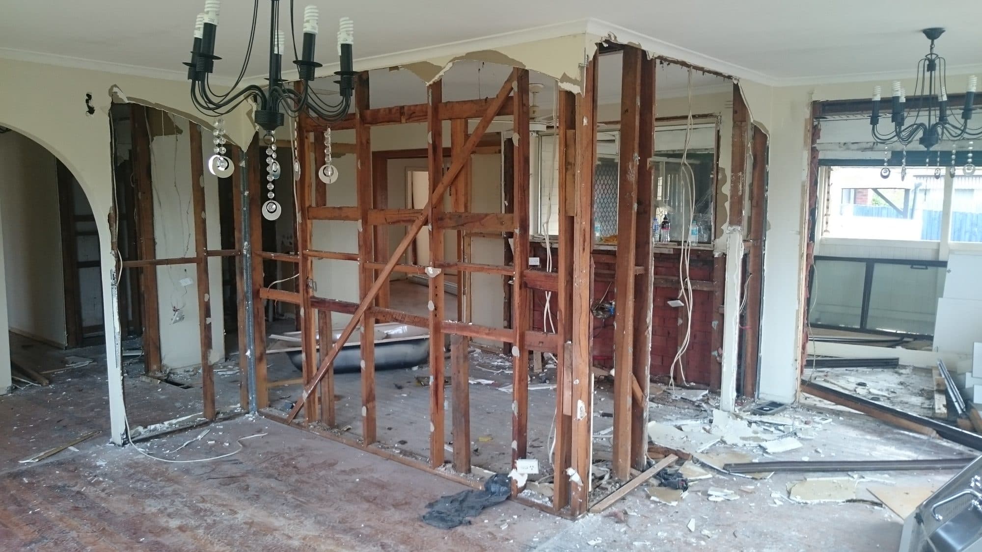 Internal walls stripped back to their timber frames, with the old linings on the floor