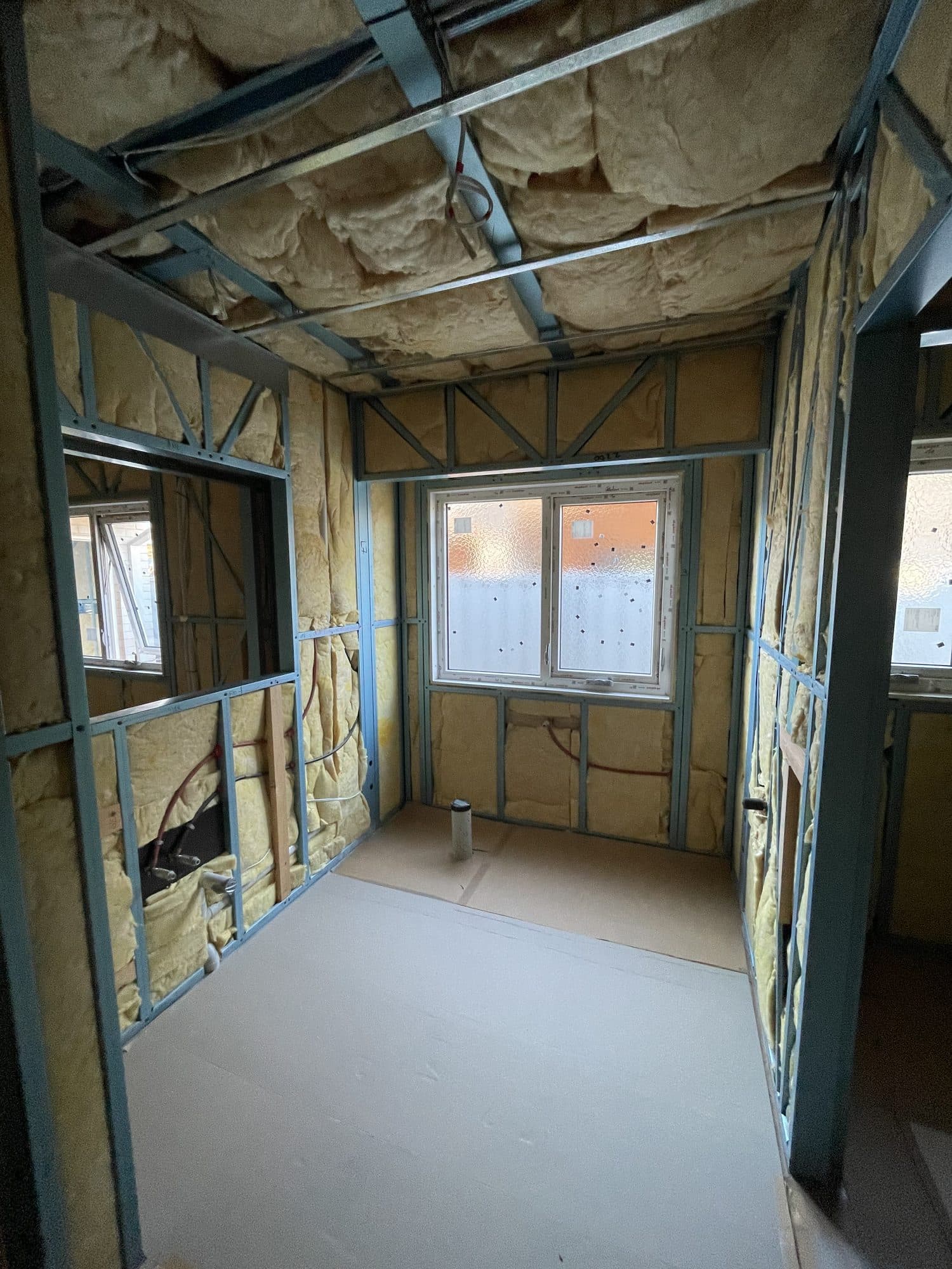 A bathroom in steel framing with insulation in the walls and ceiling