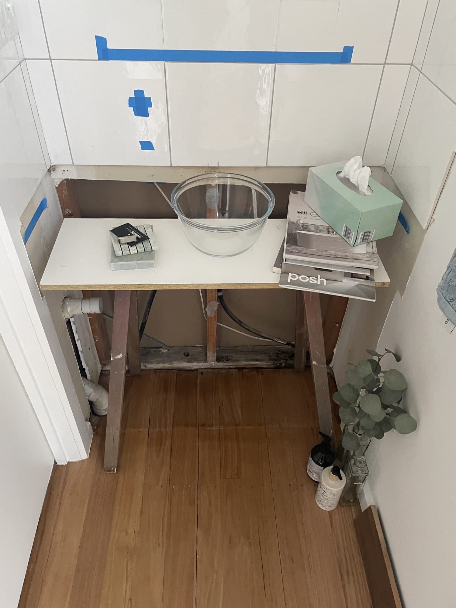 The powder room before, with a temporary bench and an opened wall