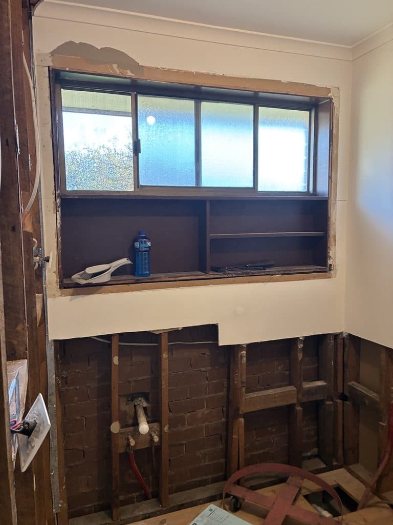 The window wall stripped back to brick and framing