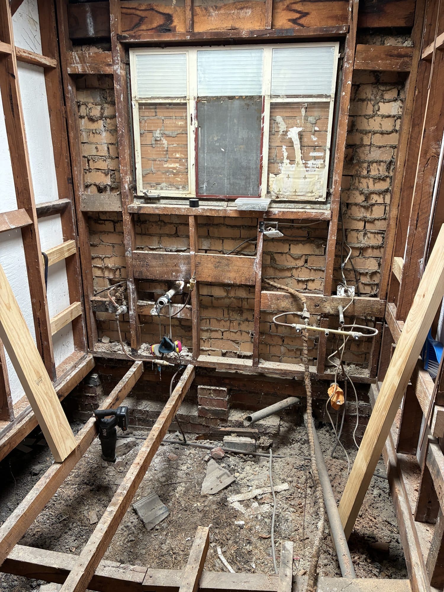 The floor opened up to the subfloor, with old pipes exposed