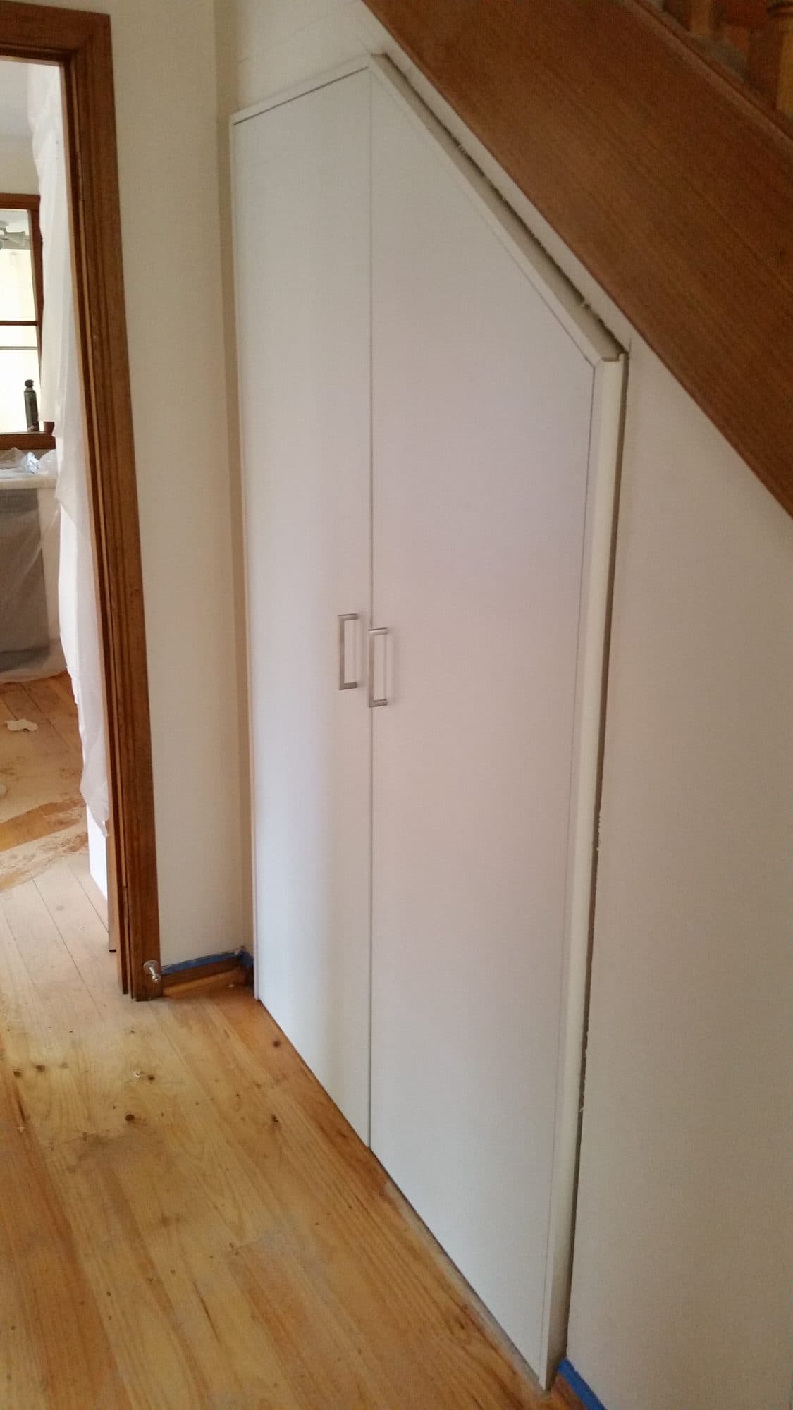 White cupboards filling the space under the stair