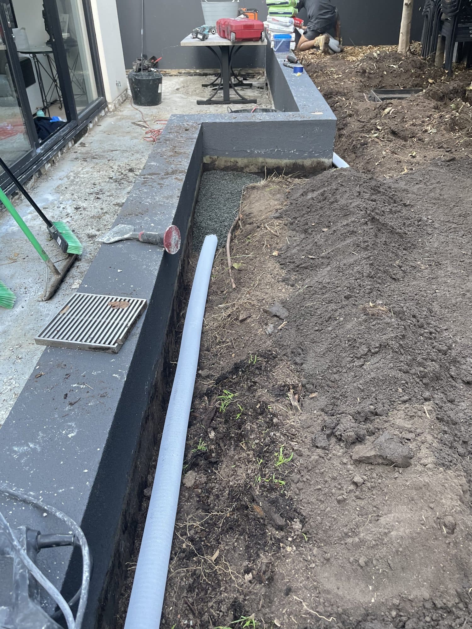 A drainage pipe laid along the base of the bed