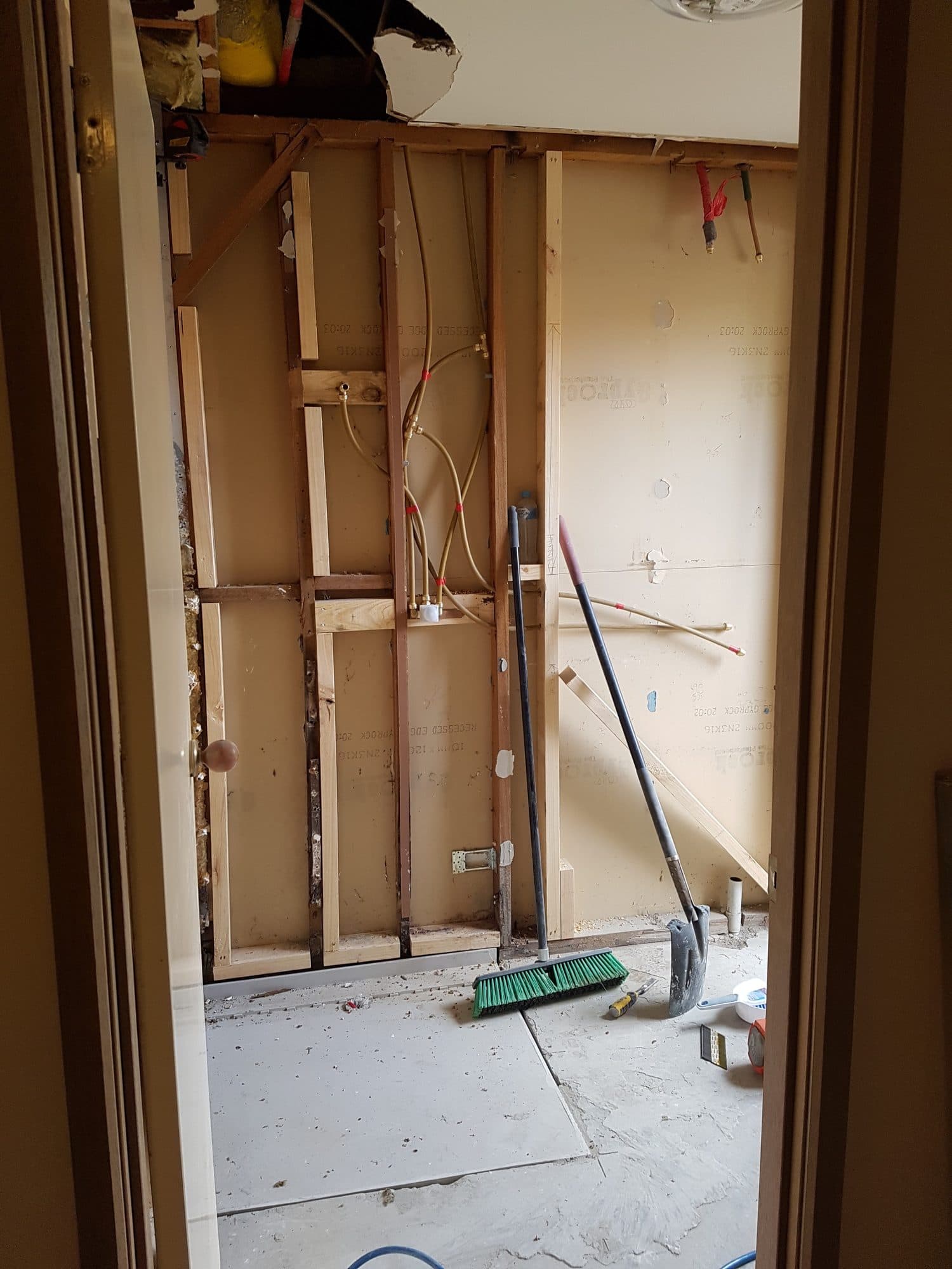 The ensuite stripped to its wall frames, from the doorway