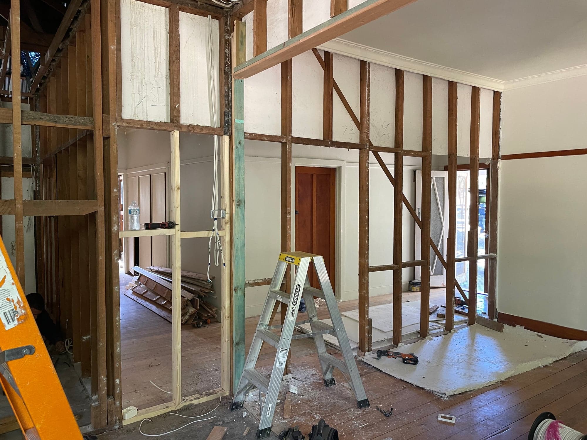 A room stripped to the studs with the ceiling open to the rafters