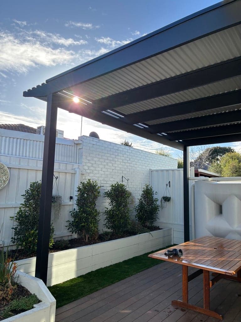 The timber pergola along the planter bed and boundary wall