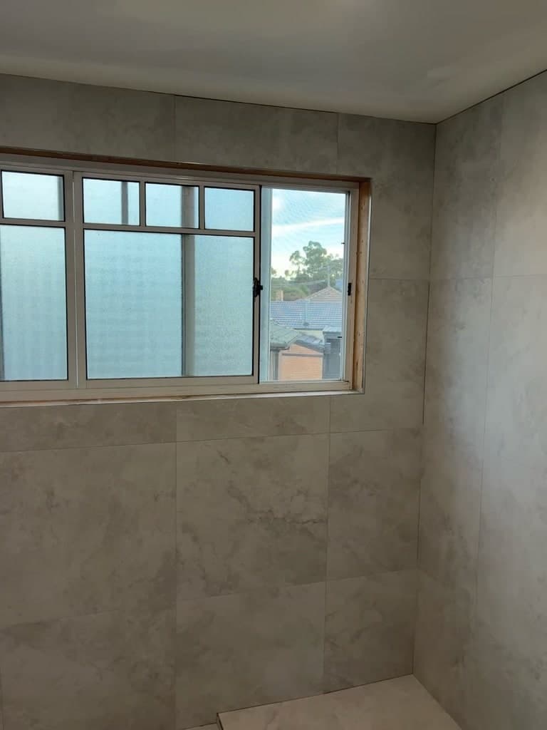 The corner of the room tiled floor to ceiling