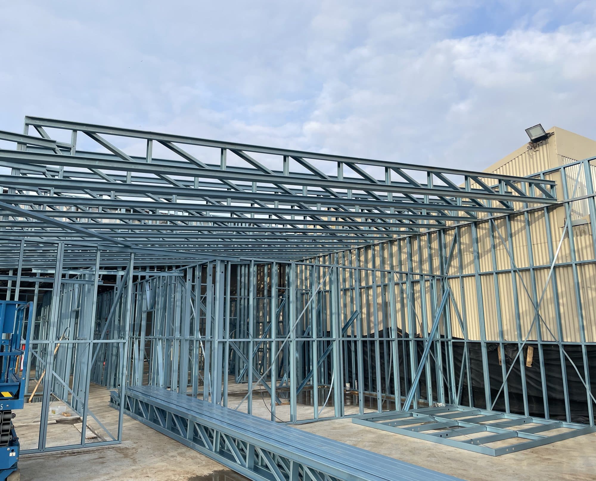 Steel roof trusses over new stud walls