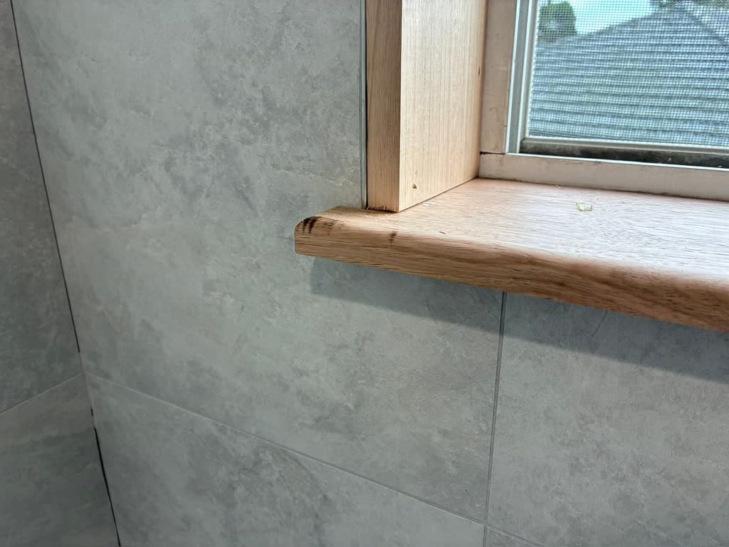 The timber sill set into the tiled window reveal