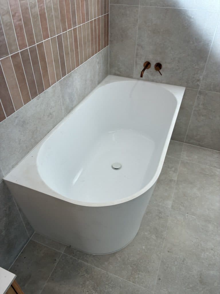 A back-to-wall bath with a brass spout