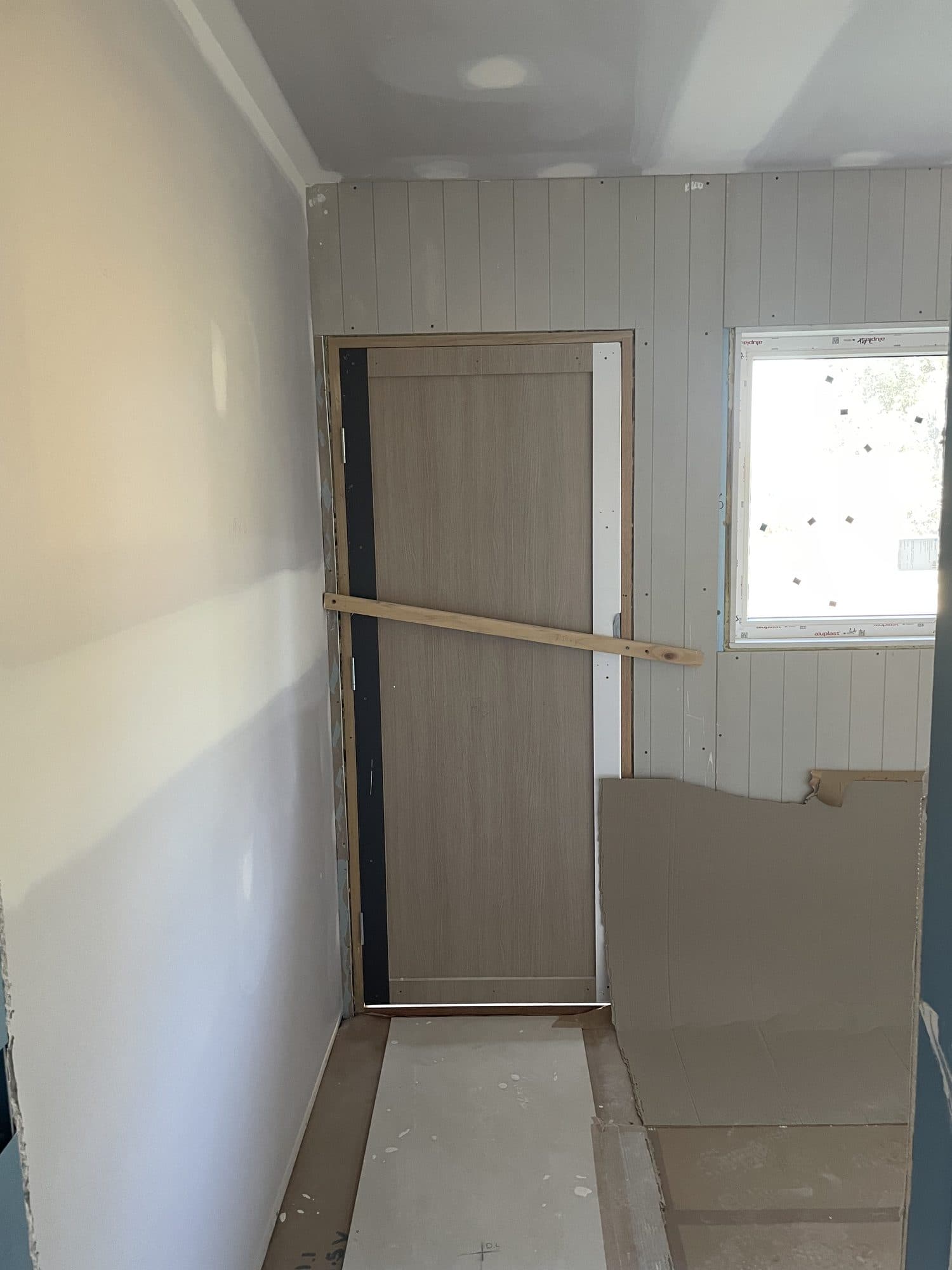 A hallway with lined walls and a door fitted