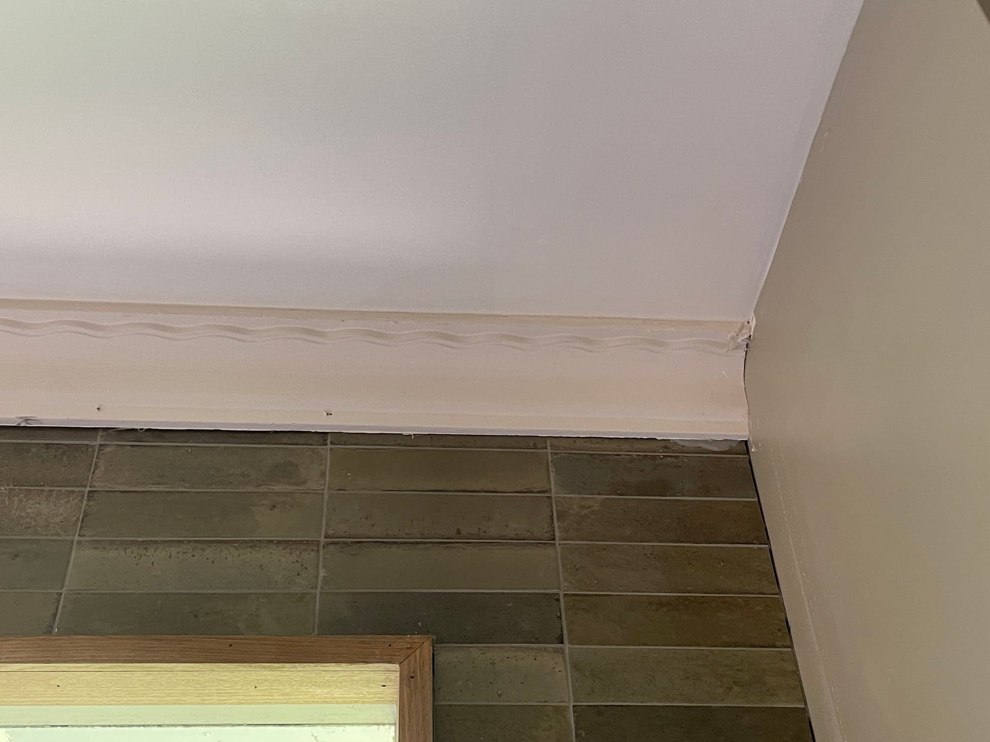 Large-format tile running up a raked bathroom wall
