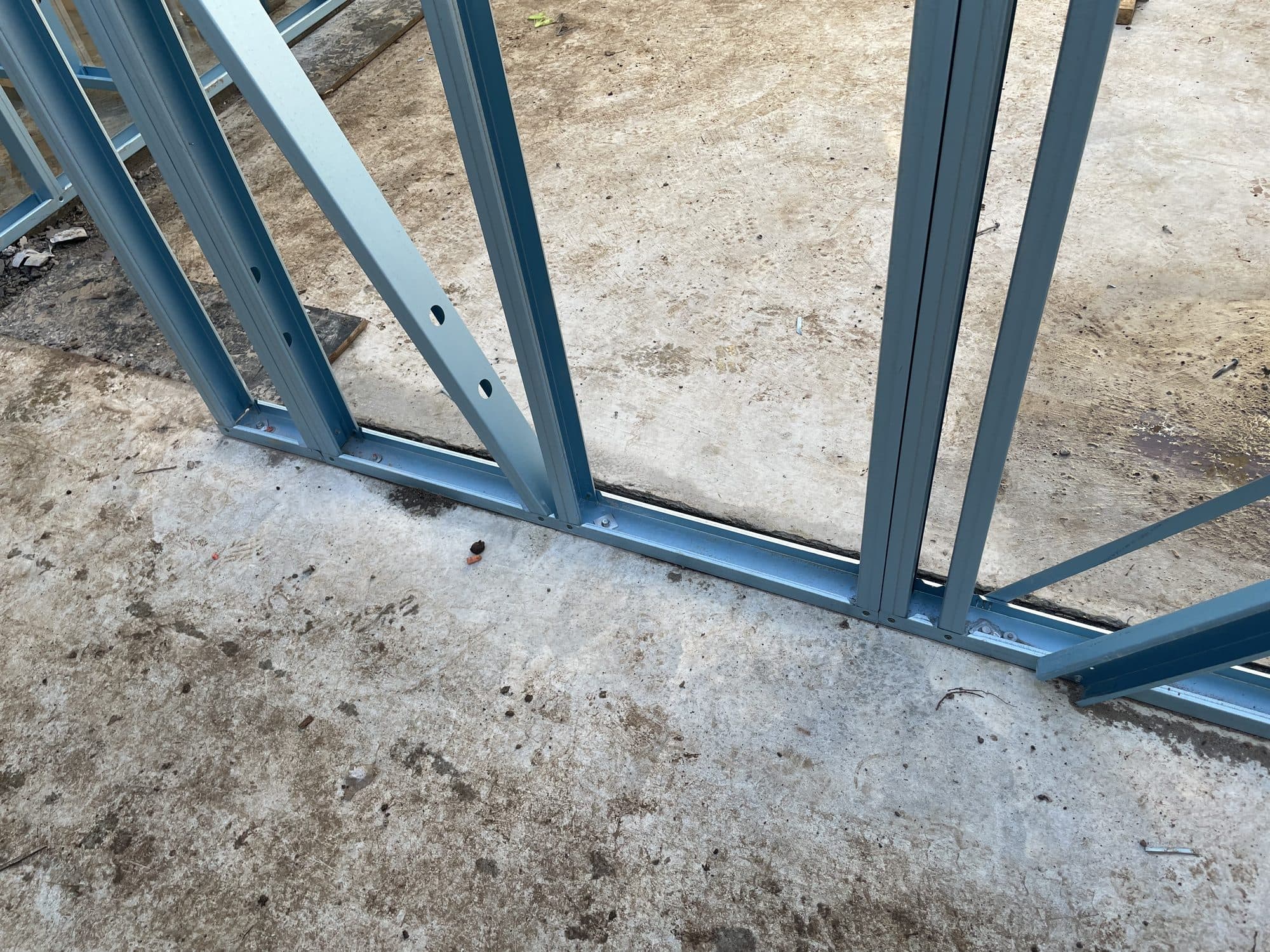 Steel wall framing fixed down to the concrete slab