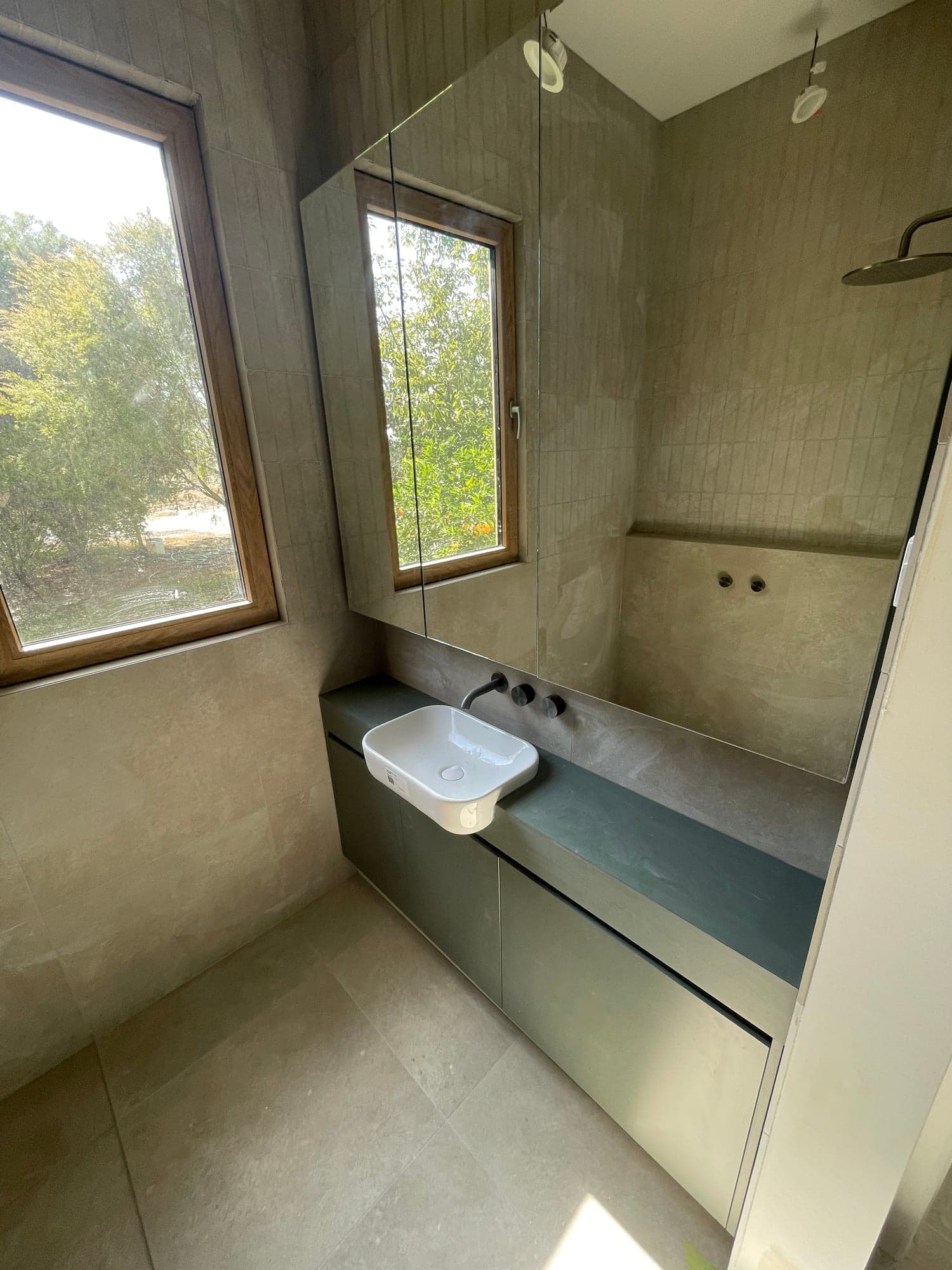 The finished bathroom: a walk-in shower with a bench seat and a window above it